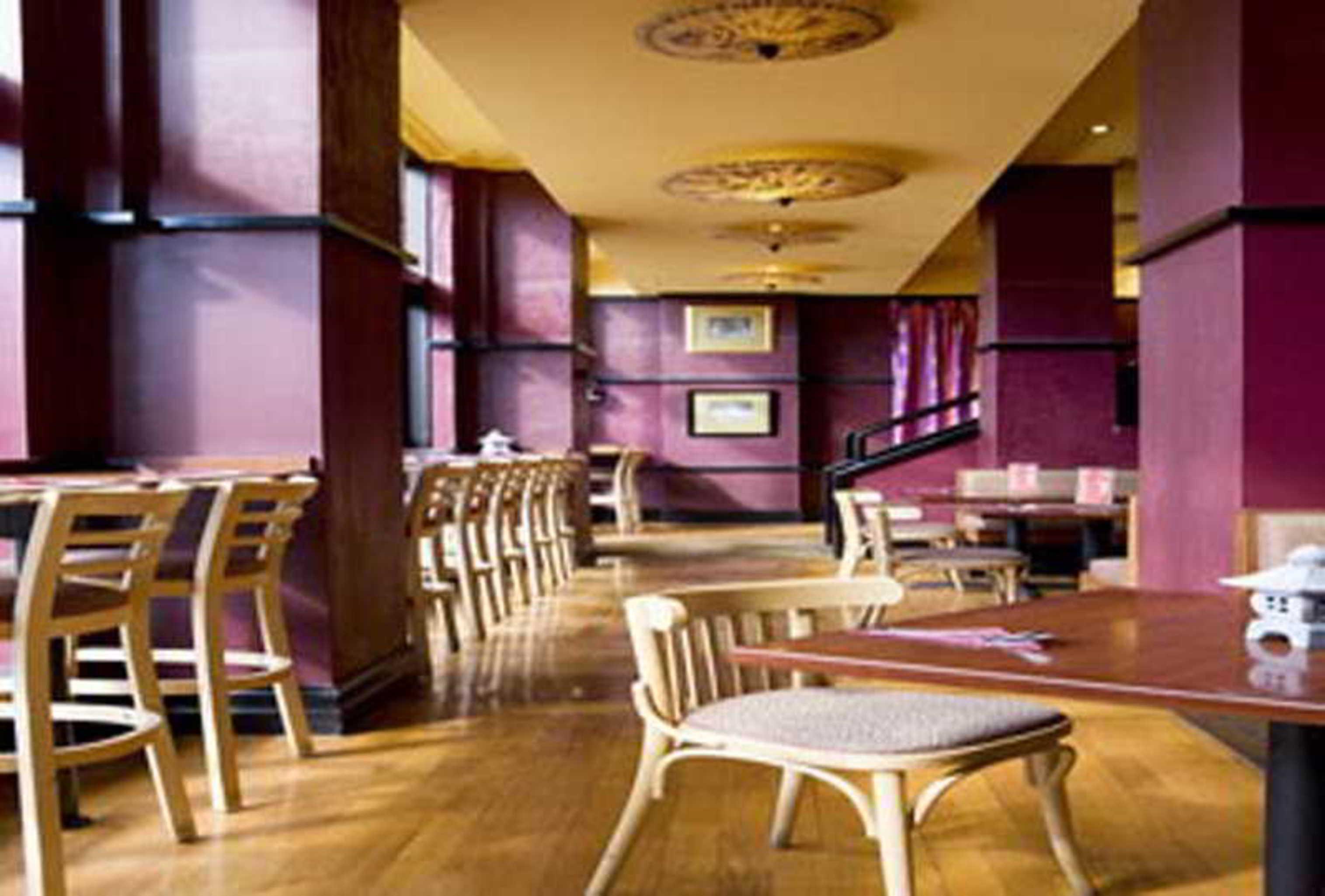 Stamford Grand Adelaide Hotel Glenelg Eksteriør billede The photo shows the interior of a restaurant. It features wooden flooring and a warm color palette, primarily using shades of burgundy and gold. There are several wooden chairs arranged around tables, with the seating area appearing spacious and invi